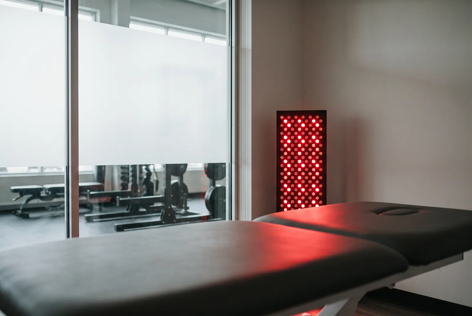 A red light therapy panel glowing in a quiet treatment room