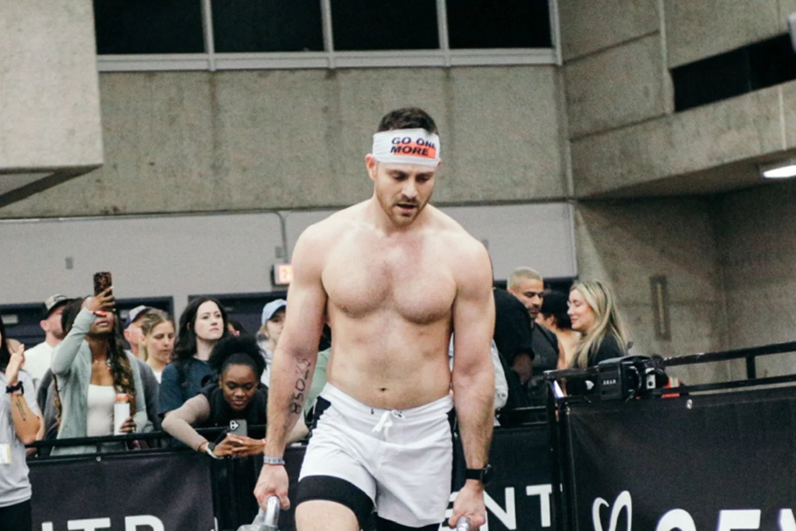 Storm Wilson carrying kettlebells during a HYROX race