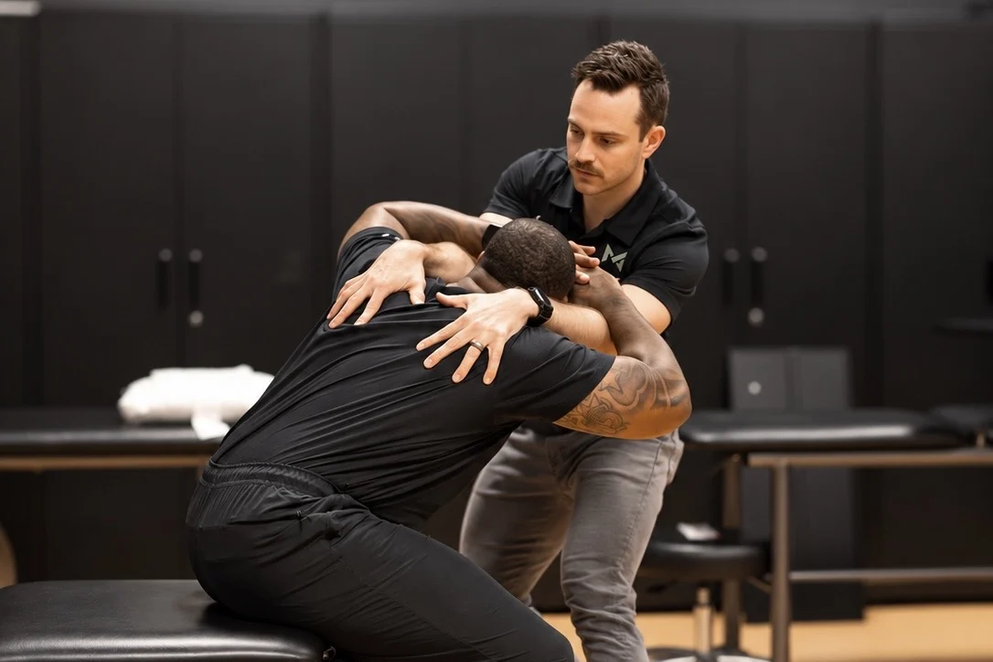 Storm Wilson guiding a patient through a hands-on movement assessment at MOTiV in Chattanooga